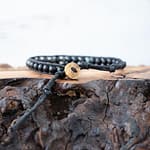 Back View of the Lotus & Luna Surf Rider Camouflage bracelet on a piece of wood against a white rustic wood background