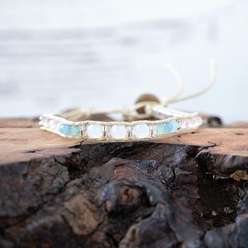 Lotus & Luna moonstruck moonstone bracelet laying on a piece of wood with white rustic wood background